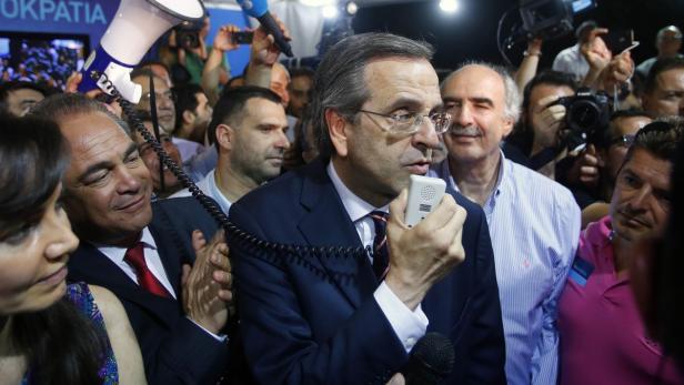 Antonis Samaras spricht in einem Gedränge in ein Mikrofon.