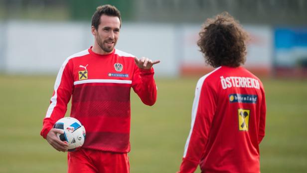 Zwei österreichische Fußballspieler in Trainingskleidung auf dem Platz.