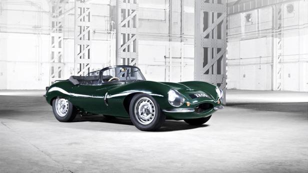 Ein grüner Jaguar D-Type Oldtimer steht in einer Lagerhalle.
