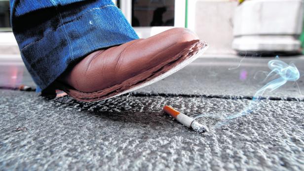 Schuh steigt auf Zigaretten-Reste