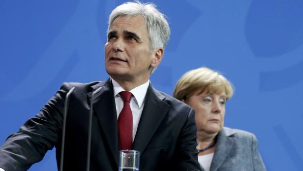 Wolfgang Schäuble spricht, während Angela Merkel im Hintergrund steht.