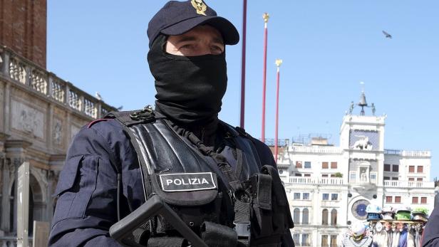 Ein Polizist mit Sturmhaube steht in Venedig vor dem Markusplatz.