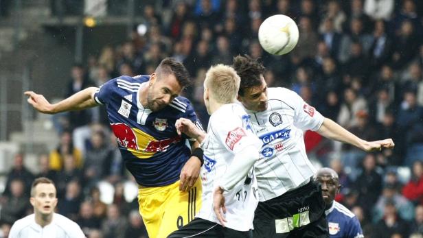 Fußballspieler kämpfen um den Ball während eines Spiels.