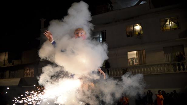 Eine Donald Trump-Figur inmitten von Rauch und Feuerwerk bei einer öffentlichen Veranstaltung.
