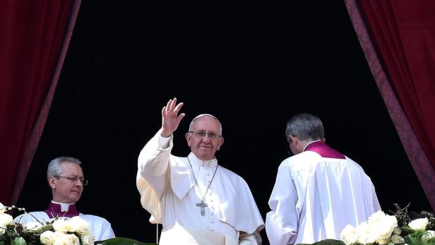 Papst Franziskus winkt von einem Balkon.