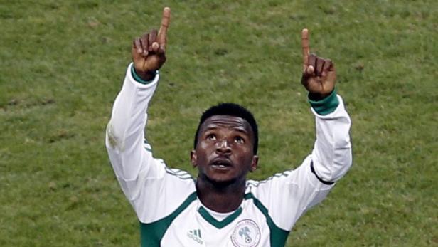 Ein Fußballspieler im Trikot von Nigeria jubelt mit erhobenen Zeigefingern.