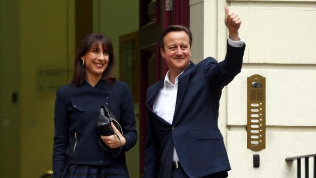 Premier und wohl bleibender Premier David Cameron und seine Frau Samantha siegessicher am Freitagmorgen