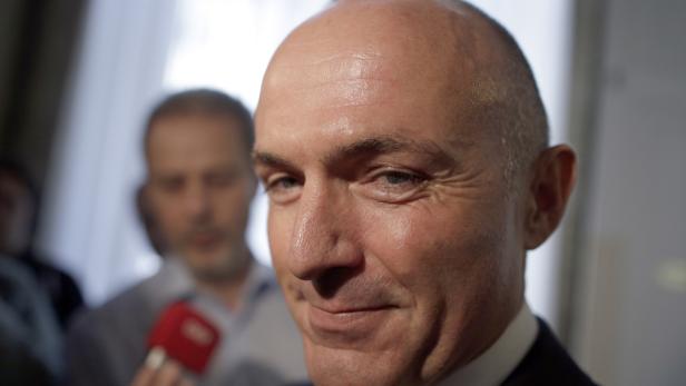 Ein Mann mit Glatze lächelt in die Kamera, während er interviewt wird.