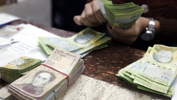 Ein Bankangestellter in Caracas zählt Geldscheine.