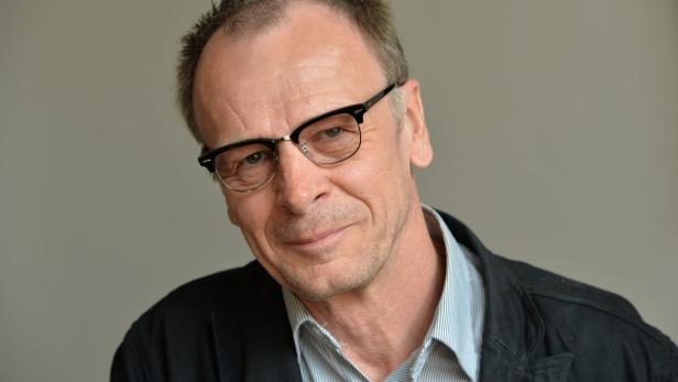 Ein Mann mit Brille und Hemd blickt in die Kamera.
