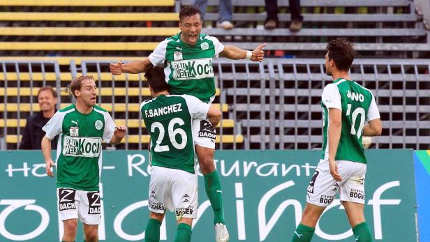 Fußballspieler wird von seinem Teamkollegen auf den Schultern getragen, um einen Sieg zu feiern.