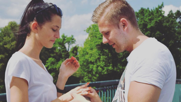 Ein Mann steckt einer Frau einen Ring an den Finger.