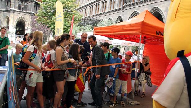 Schaulustige beobachten einen Mann hinter einer Absperrung vor dem Wiener Rathaus.