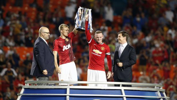 Wayne Rooney und ein weiterer Spieler von Manchester United halten eine Trophäe in die Höhe.