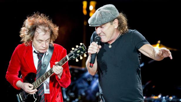 Angus Young spielt Gitarre, während Brian Johnson von AC/DC singt.