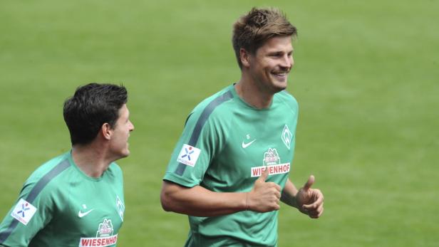 Zwei Fußballspieler von Werder Bremen in grünen Trikots beim Training.