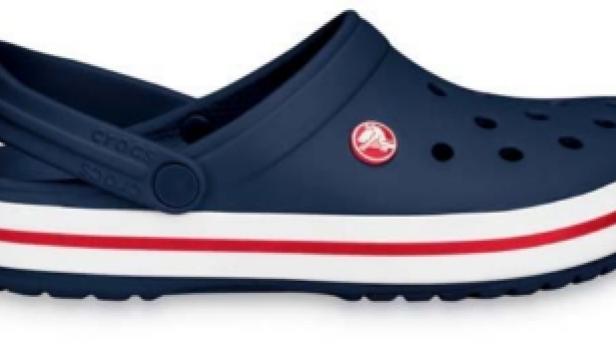 Ein marineblauer Crocs-Clog mit weißen und roten Streifen an der Sohle.