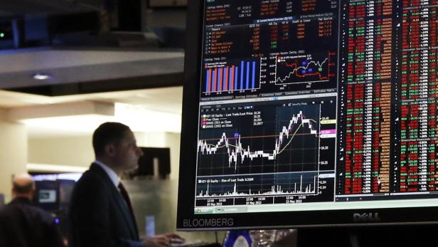 Ein Mann betrachtet einen Bloomberg-Bildschirm mit Finanzdaten und Diagrammen.