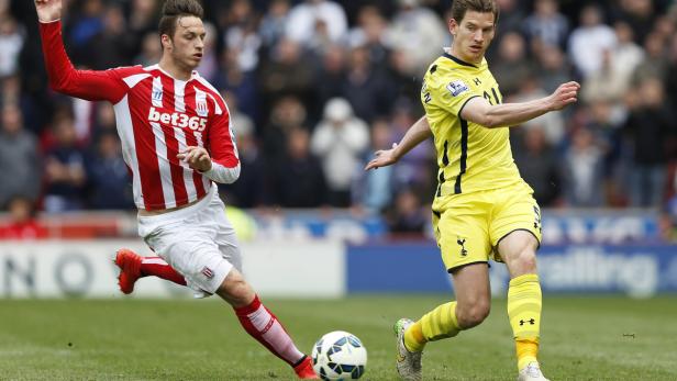 Zwei Fußballspieler kämpfen um den Ball auf dem Spielfeld.