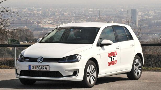 Ein weißer VW e-Golf mit „Kurier Test Kurier“-Aufkleber vor der Skyline von Wien.