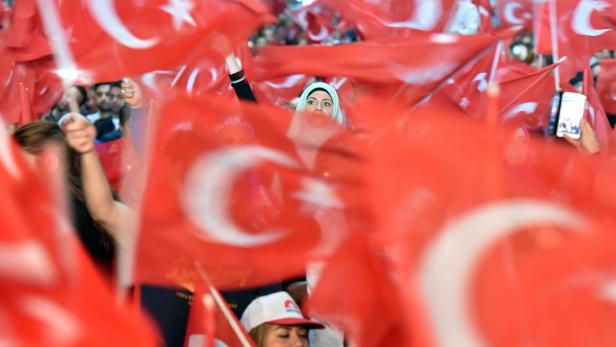 Eine Menschenmenge schwenkt türkische Flaggen.