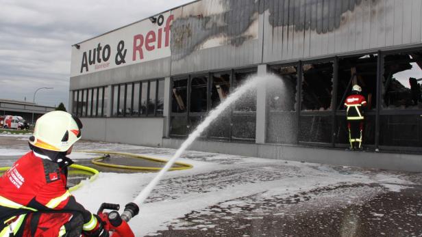Feuerwehrleute löschen einen Brand in einem Gebäude von „Auto & Reif Mannrieser“.
