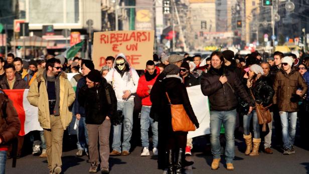 Eine Menschenmenge demonstriert mit einem Schild, auf dem „Ribellarsi è un dovere“ steht.