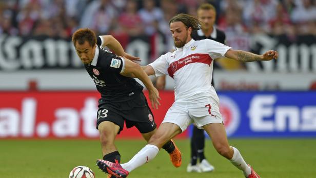 Zwei Fußballspieler kämpfen um den Ball auf dem Spielfeld.