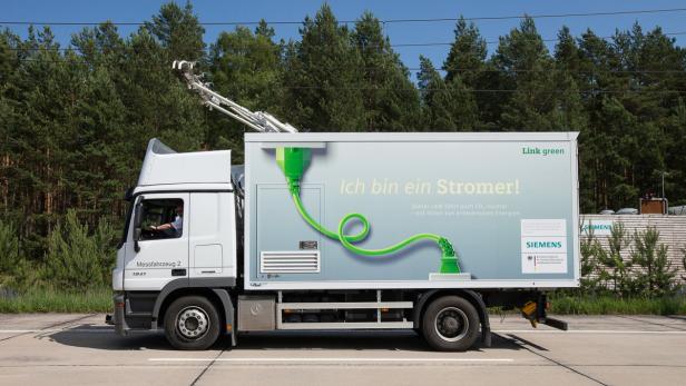 Ein elektrisch betriebener LKW mit Oberleitungsanschluss fährt auf einer Straße.