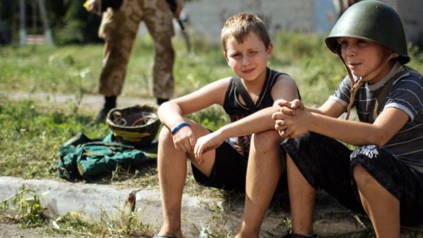 Kinder vor ihrer Schule in der Ostukraine, die dem gegen die Separatisten vorrückenden Militär als Lager dient