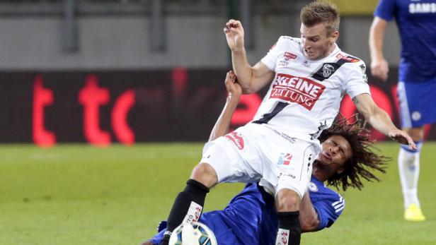 Zwei Fußballspieler kämpfen um den Ball während eines Spiels.