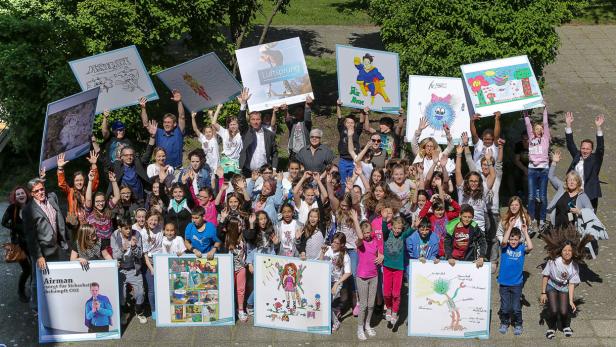 Eine große Gruppe von Kindern und Erwachsenen hält selbstgemalte Bilder hoch.
