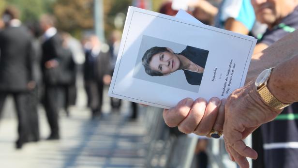 Ein Mann hält die Traueranzeige für Barbara Prammer, Präsidentin des Nationalrates.