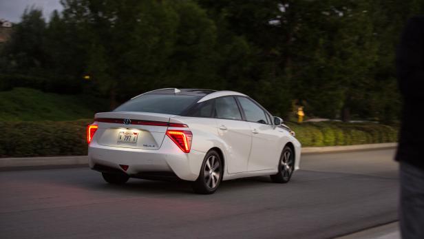 Ein weißer Toyota Mirai fährt auf einer Straße.