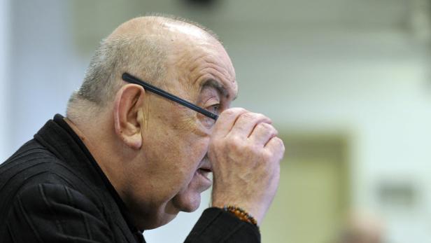 Ein Mann mit Brille blickt aufmerksam zur Seite.