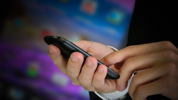 Eine Person bedient ein Smartphone mit dem Daumen.