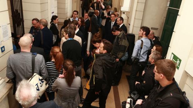 Eine Menschenmenge versammelt sich in einem hellen Gebäude.