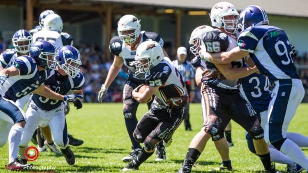 Ein American-Football-Spieler wird von mehreren Gegenspielern attackiert.
