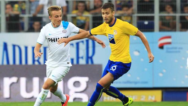 Zwei Fußballspieler kämpfen um den Ball auf dem Spielfeld.