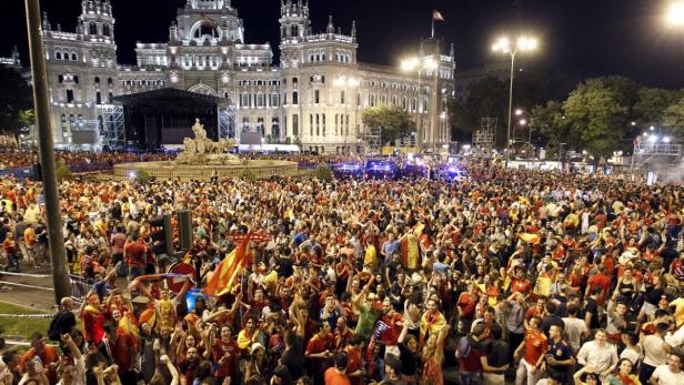 Eine große Menschenmenge feiert auf einem Platz in Madrid, Spanien.