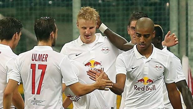 Fußballspieler von RB Leipzig feiern gemeinsam auf dem Spielfeld.