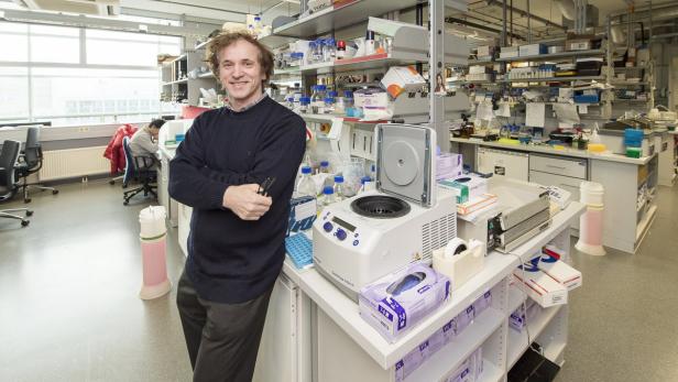 Ein Mann steht in einem Labor neben einer Zentrifuge.