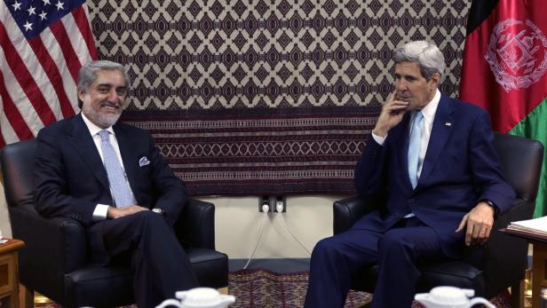 Abdullah Abdullah und John Kerry sitzen in Sesseln vor den Flaggen der USA und Afghanistans.