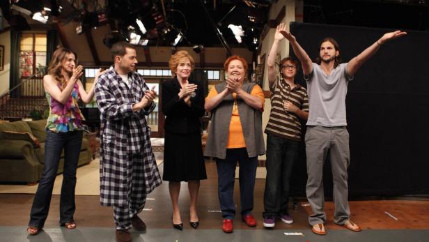 Die Besetzung von „Two and a Half Men“ steht auf der Bühne und applaudiert.