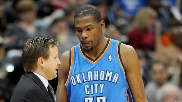 Kevin Durant im Gespräch mit seinem Trainer während eines Basketballspiels.