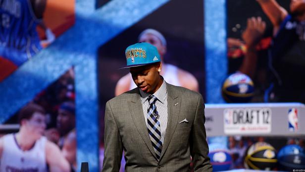 Ein junger Mann mit Anzug und Kappe der New Orleans Hornets beim NBA-Draft 2012.