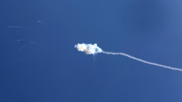 Am Himmel sind Kondensstreifen und eine Rauchwolke zu sehen.