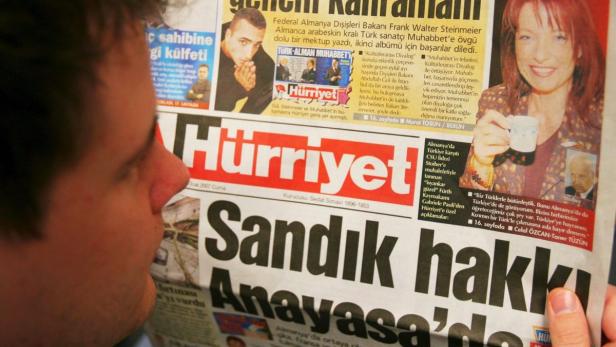 Eine Person liest eine Ausgabe der türkischen Zeitung Hürriyet.