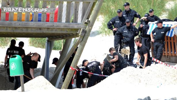 EPAepa03295054 Police dig under the playground equipment Piratenschiff (Pirate Ship) on Amrum island in Wittduen, Germany, 04 July 2012. Police found the body of a child presumed to be Sebastian (10) from Austria. Since he went missing on Sunday, there ha Obduktion: Sebastian im Sand erstickt