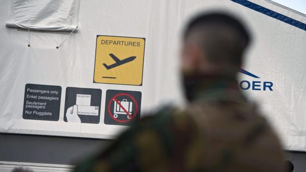 Ein Schild mit der Aufschrift „Departures“ und Piktogrammen für einen Flughafen.